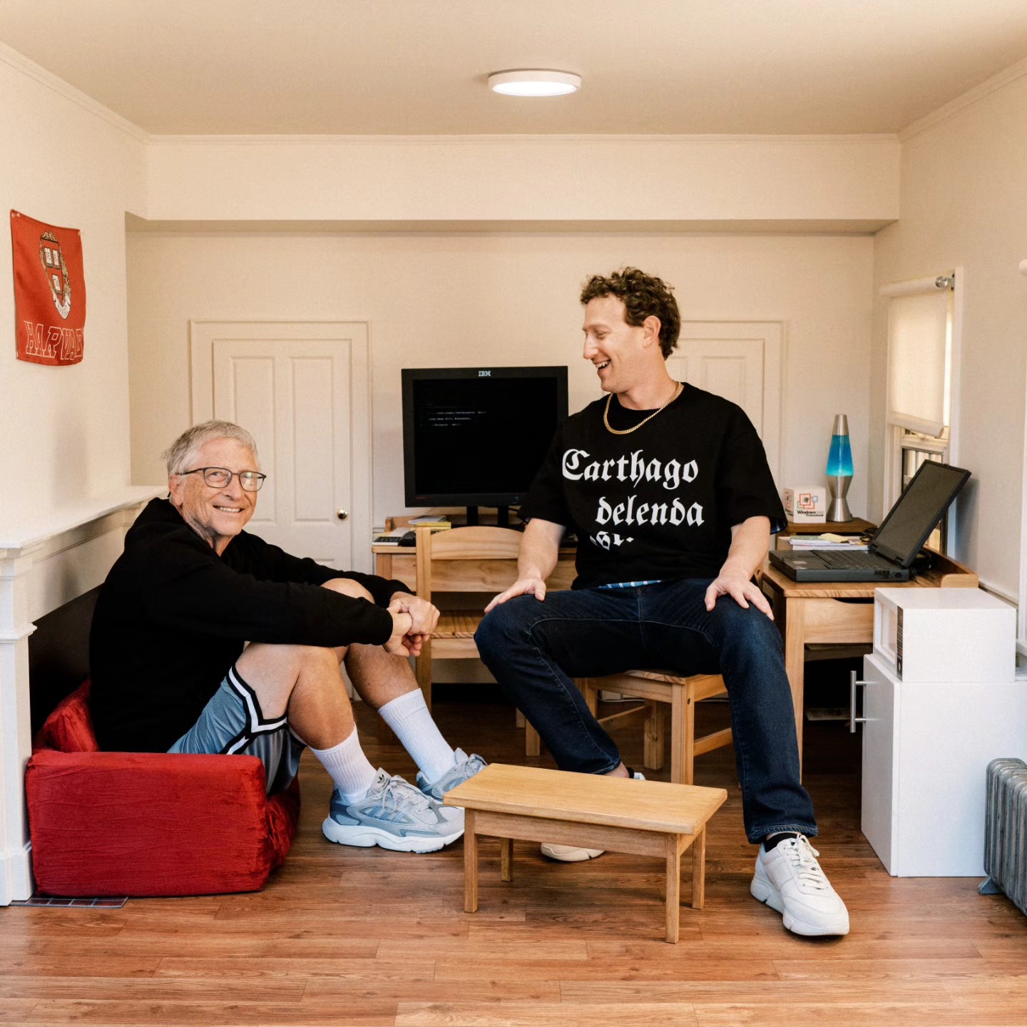 Mark Zuckerberg, wearing a t-shirt reading “Carthago delenda est”, sitting with Bill Gates in a recreation of his old Harvard dorm room.